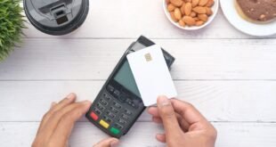 a person holding a credit card next to a calculator