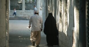 a man walking with a person in a black robe