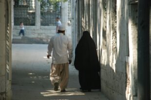 a man walking with a person in a black robe