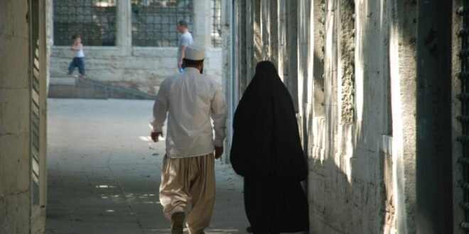 a man walking with a person in a black robe